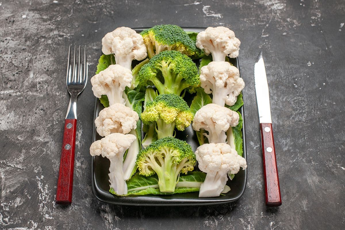broccoli cauliflower in plate with spoon and knife
