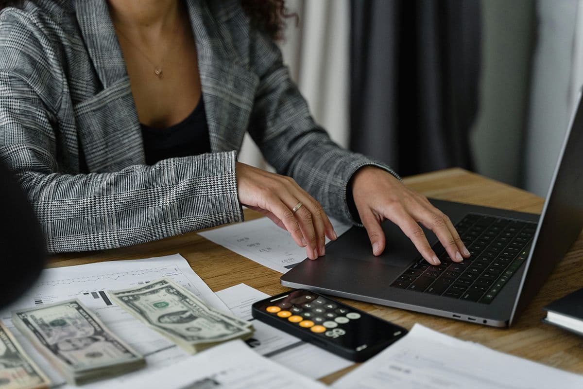 typing on laptop and money, calculator