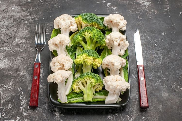 broccoli cauliflower in plate with spoon and knife